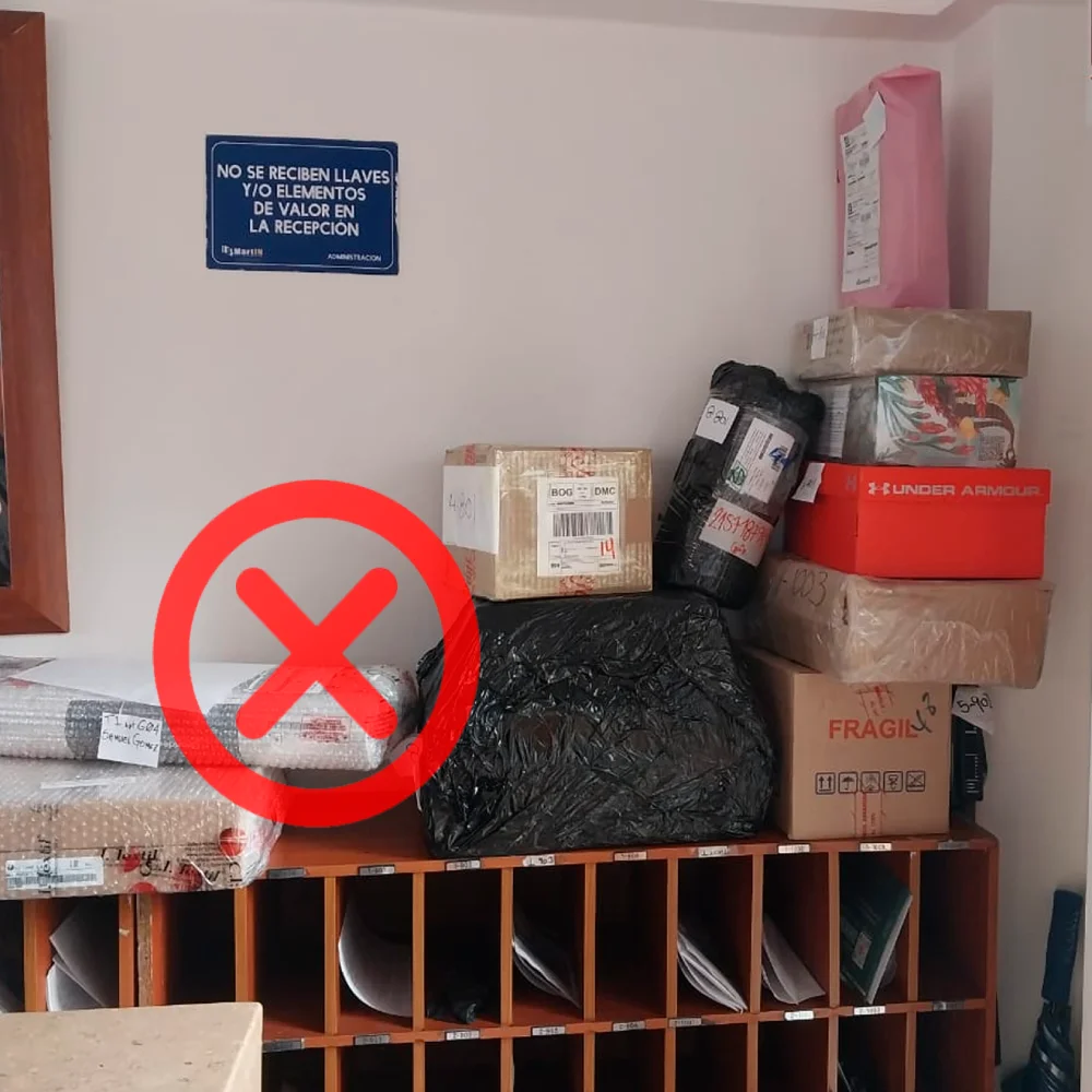 Zona de portería con paquetes acumulados sin organización visible